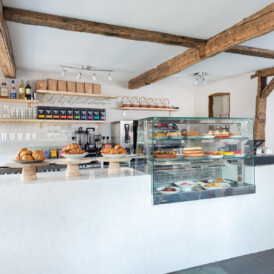 Bright café interior with original wooden beams and cake counter